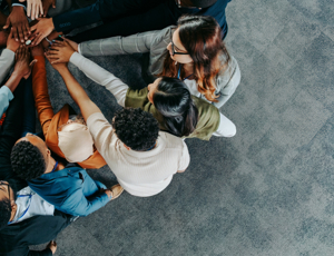 Colleagues putting their hands together in the middle