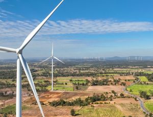 Wind turbines across a wide rural landscape on a clear, sunny day