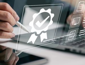 Person using a stylus on a tablet next to a laptop, with digital certification and checklist icons overlayed on the screen
