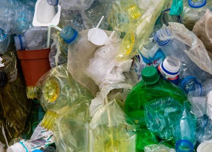 Pile of mixed plastic waste including bottles, containers, and packaging materials