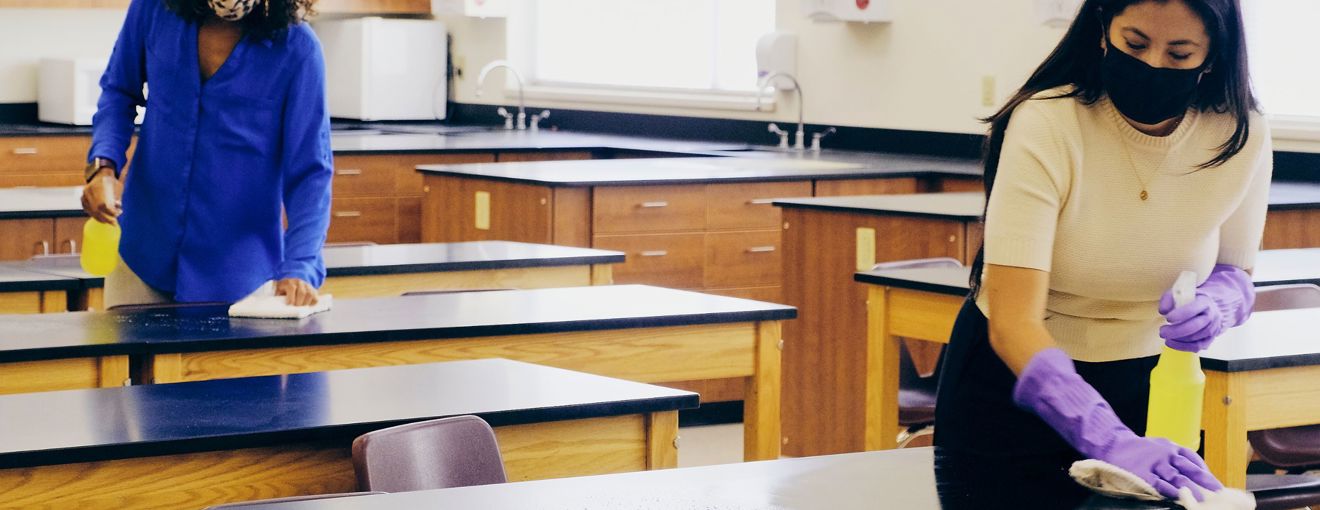 cleaners cleaning desks in a school