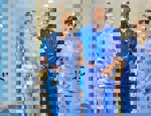 Healthcare staff walking through a hospital corridor wearing medical scrubs