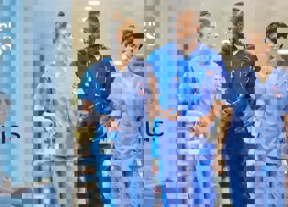 Healthcare staff walking through a hospital corridor wearing medical scrubs